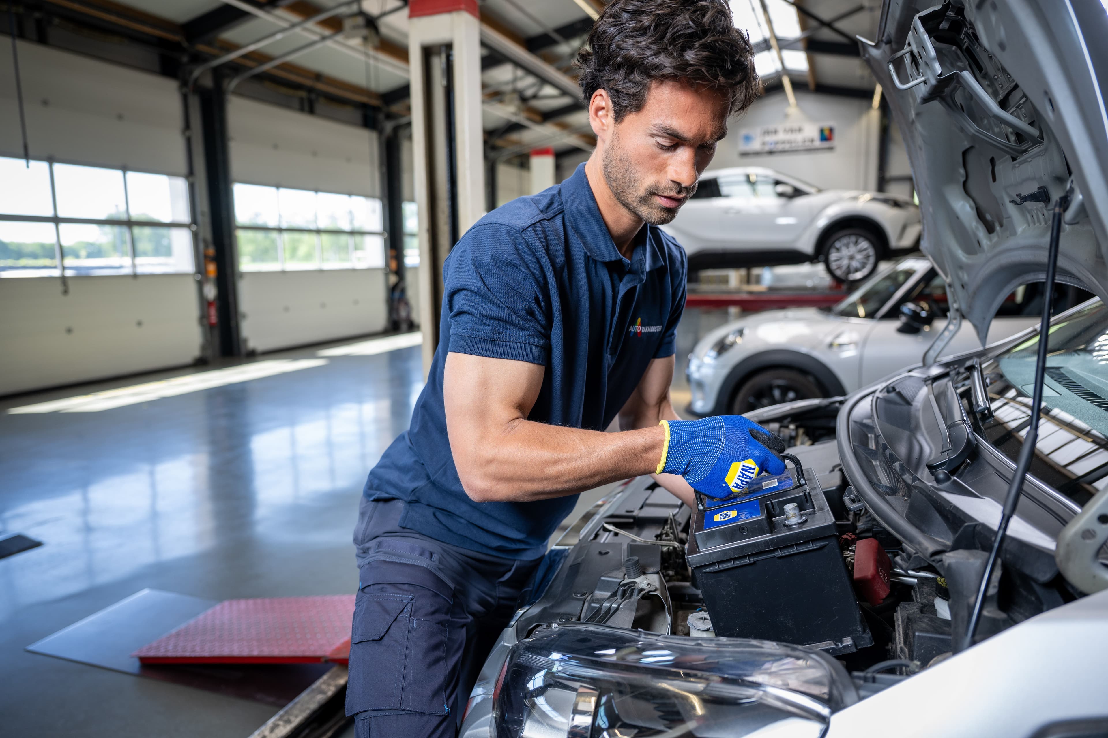 Autorepairmaster expert vervangt de batterij van de auto.